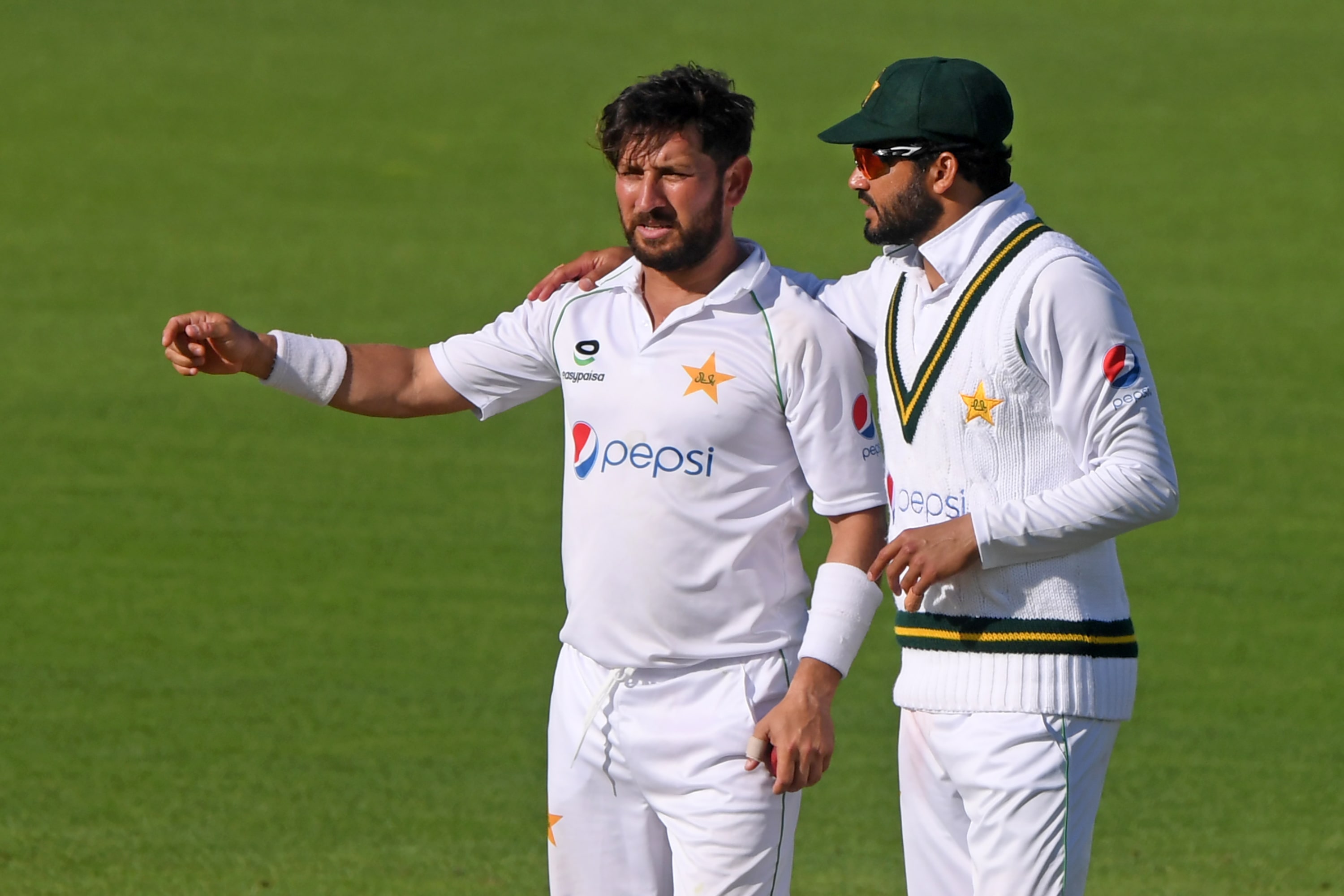 Pakistan's Azhar Ali (R) speaks with Pakistan's Yasir Shah (L) during play on the fifth day of the second Test cricket match between England and Pakistan at the Ageas Bowl in Southampton, southwest England on August 17, 2020. (AFP)