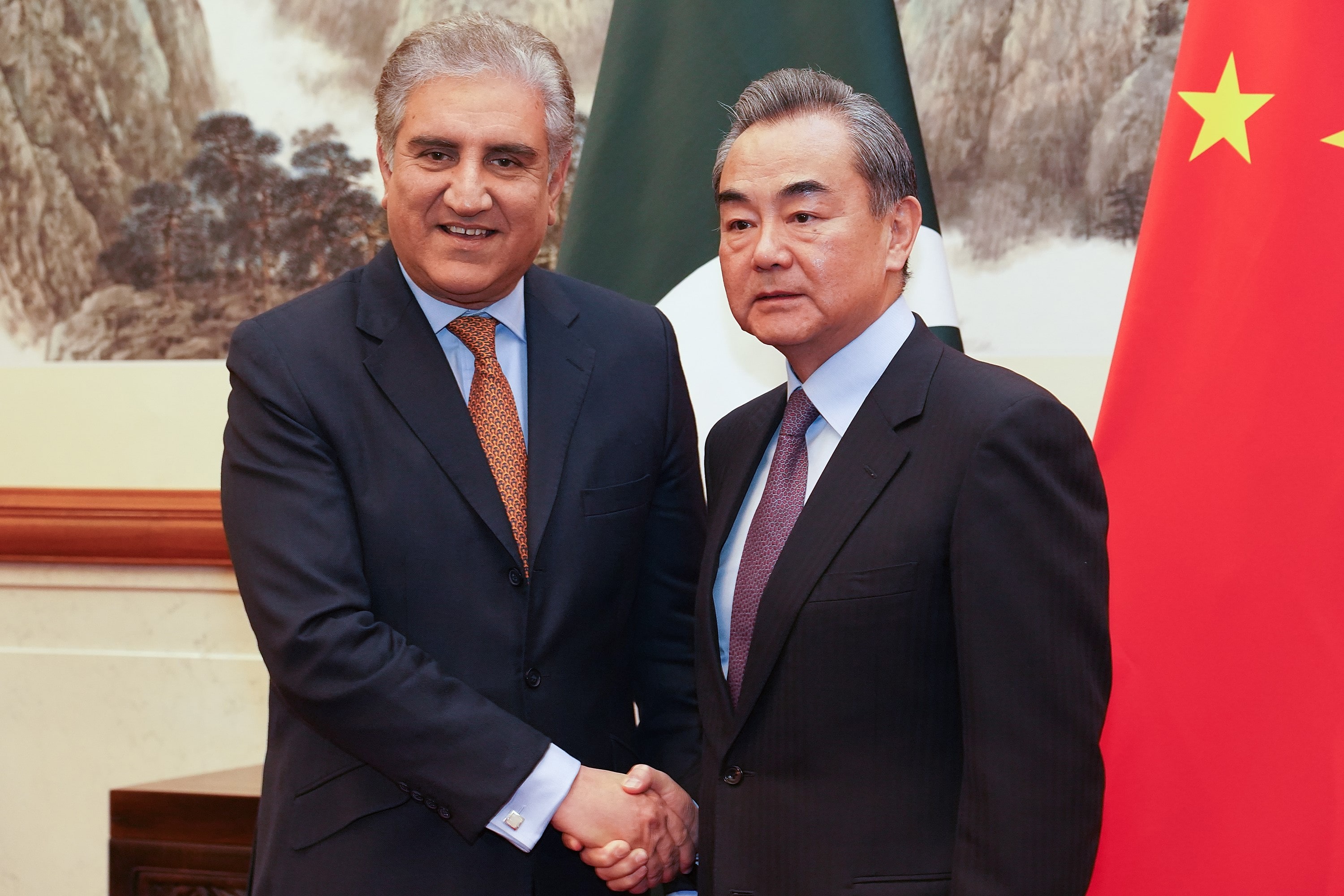 Chinese Foreign Minister Wang Yi (R) and Pakistani Foreign Minister Shah Mehmood Qureshi shake hands during their meeting in Beijing on March 19, 2019. (AFP)