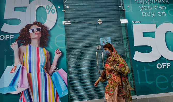 A woman walks past a shuttered market in Rawalpindi on July 29, 2020. (AFP)