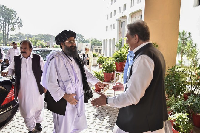 In this handout photograph taken and released by the Pakistan Foreign Ministry on October 3, 2019, Pakistan's Foreign Minister Shah Mehmood Qureshi (R) greets Taliban co-founder Mullah Baradar (2L) upon his arrival with delegation at the Pakistan Foreign Ministry in Islamabad. (AFP / Pakistan Foreign Ministry)