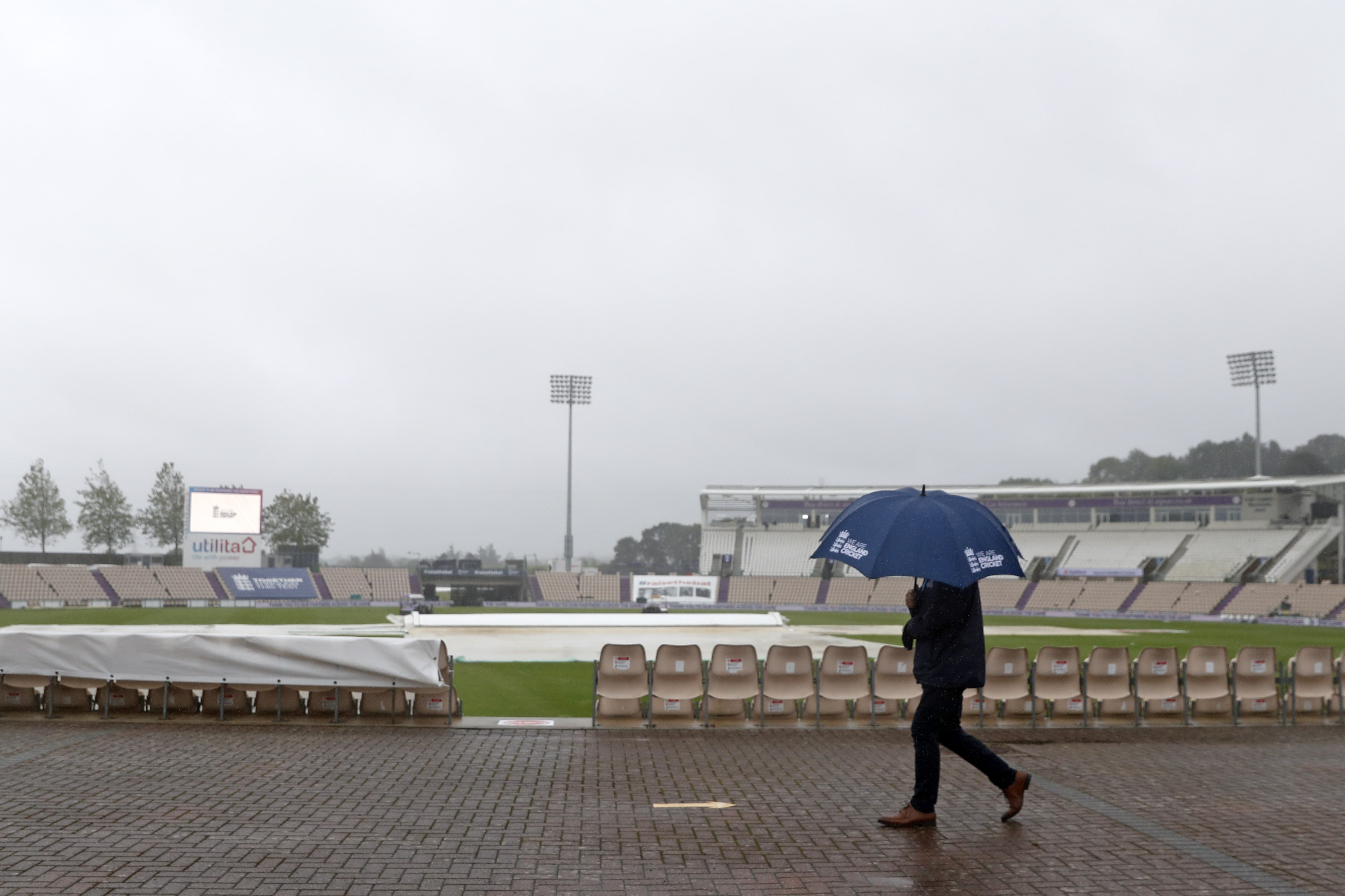 Umbrellas are the order of the day as rain prevents play starting on time on the fifth day of the third Test cricket match between England and Pakistan at the Ageas Bowl in Southampton, southern England on August 25, 2020. (AFP)