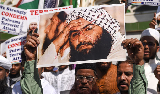 Indian Muslims hold a scratched photo of Jaish-e-Mohammad group chief, Maulana Masood Azhar, as they protest in Mumbai against Pakistan on February 15, 2019, the day after an attack on a paramilitary Central Reserve Police Force (CRPF) convoy in the Lethpora area of Kashmir. (AFP)