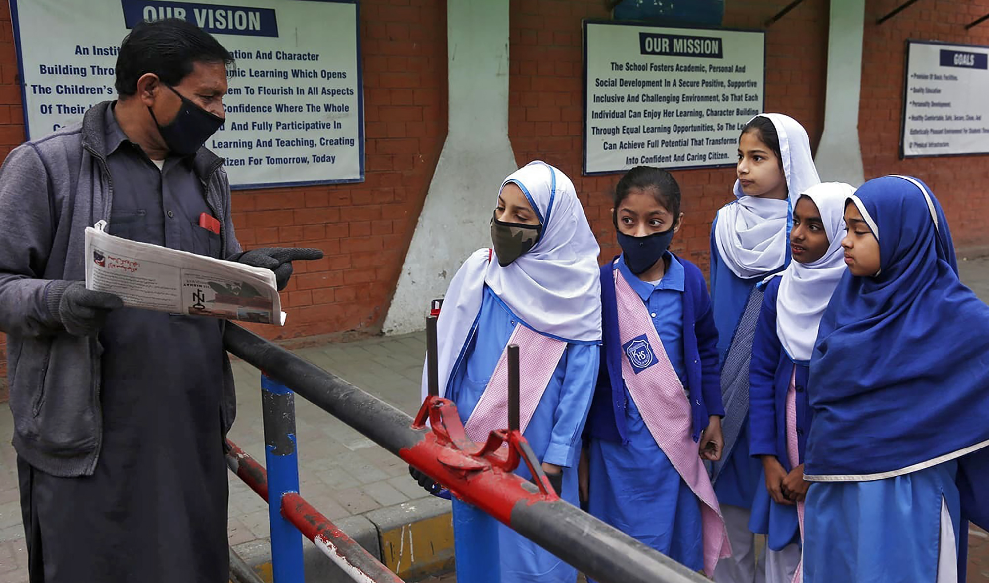A security guard tells students that their school is closed by authorities to control spread of COVID-19 coronavirus, in Lahore on March 14, 2020. (AP/File)