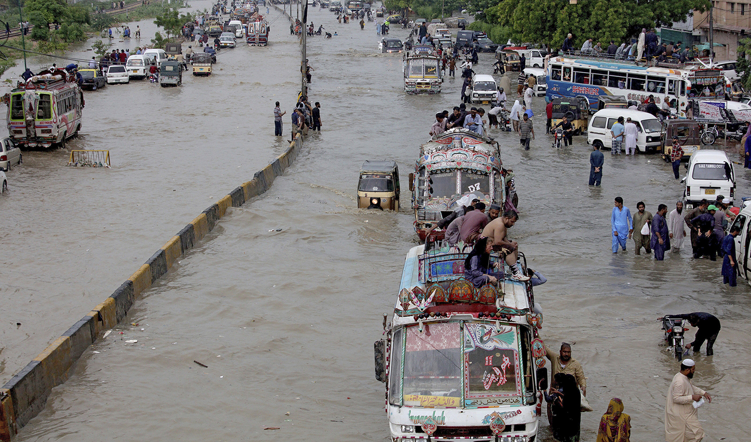 Vehicles drive through a flooded road after heavy monsoon rains, in Karachi on Aug. 27, 2020. (AP)