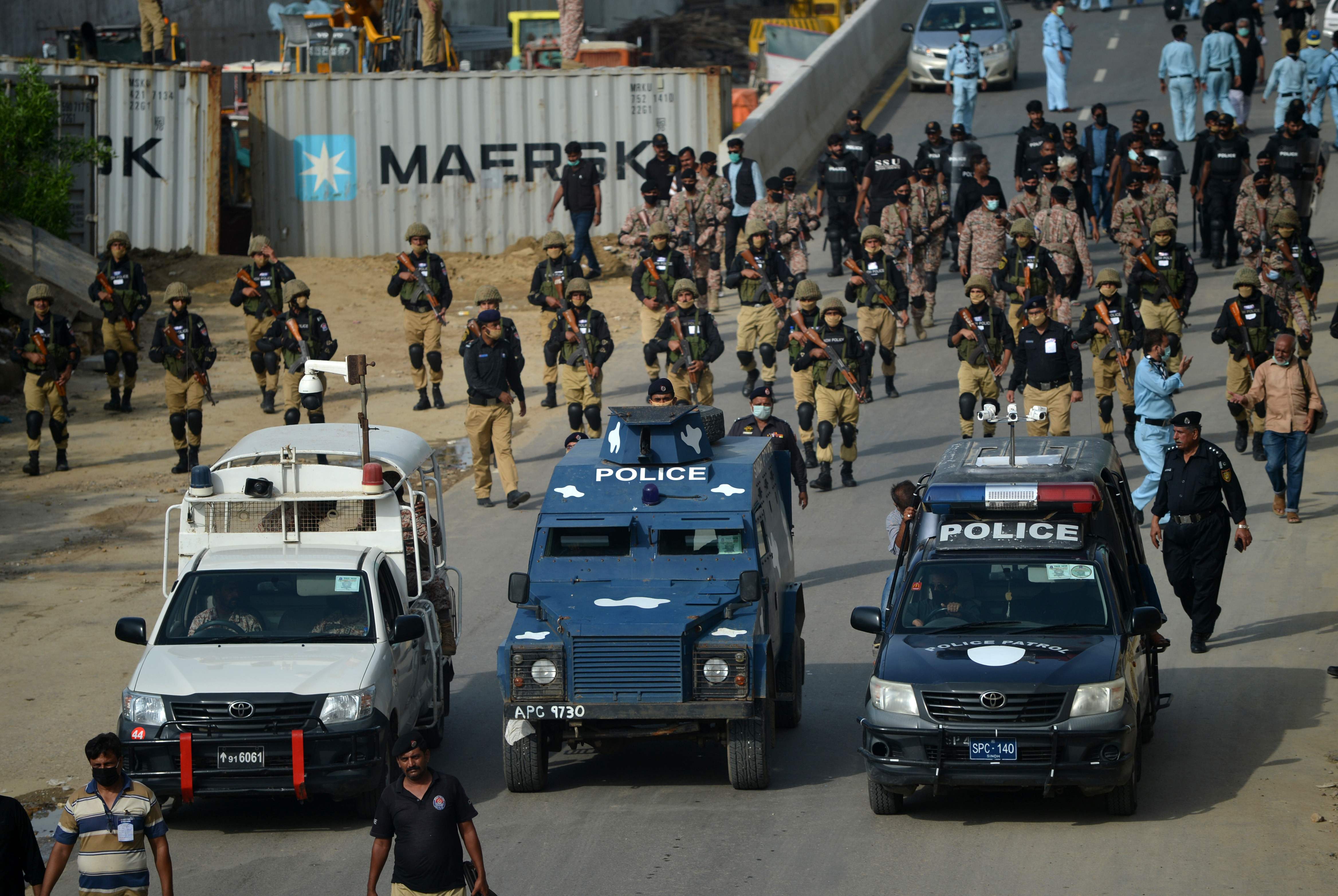 Security personnel escort a procession of Shiite Muslims for a mourning ritual during the Islamic month of Muharram ahead of Ashura ceremonies, in Karachi on August 29, 2020. (AFP)
