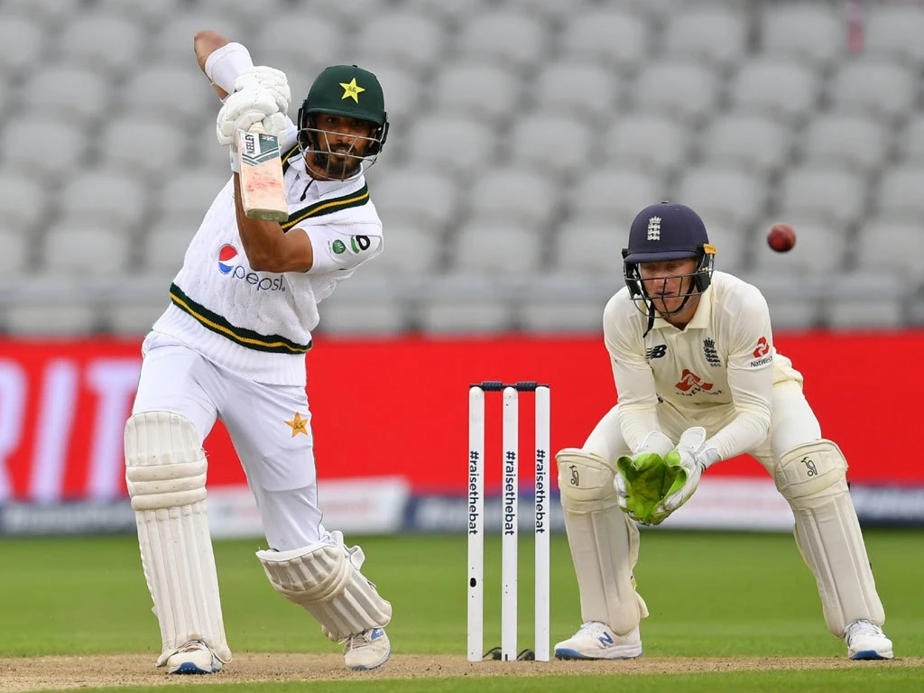 Pakistan's Shan Masood (L) plays a shot in front of England's wicket keeper Jos Buttler during the first day of the first Test cricket match between England and Pakistan at Old Trafford in Manchester, northwest England on August 5, 2020. (AFP)