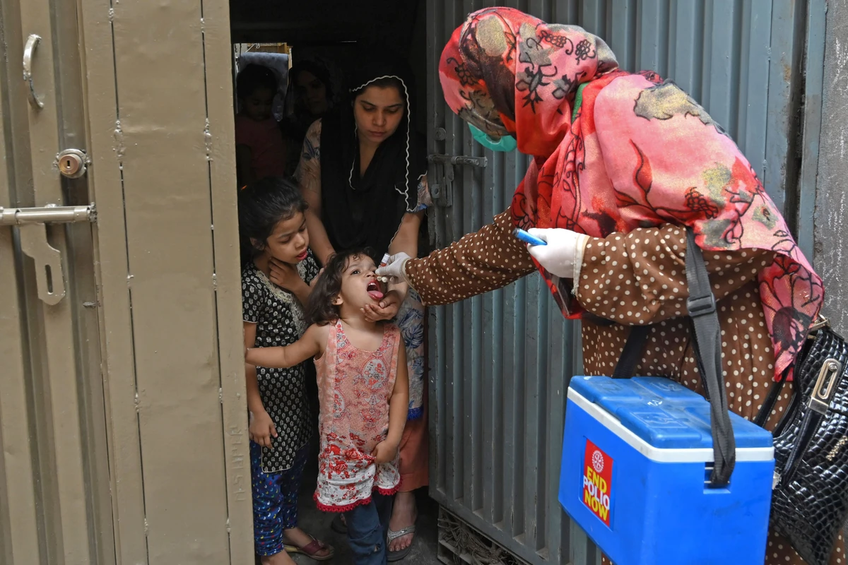 A health worker administers polio vaccine drops to a child during a polio vaccination door-to-door campaign in Lahore on July 20, 2020. (AFP)