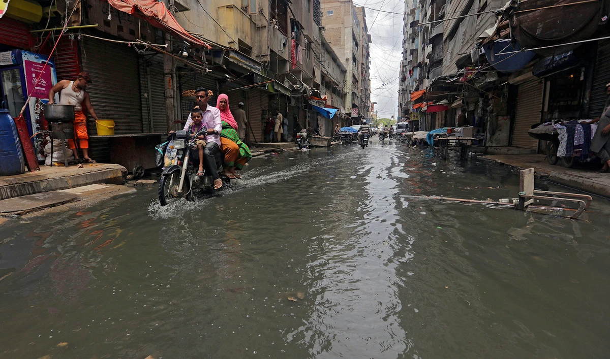 A motorcyclist drives through a street flooded by heavy rainfall in Karachi on Aug. 9, 2020. (AP)