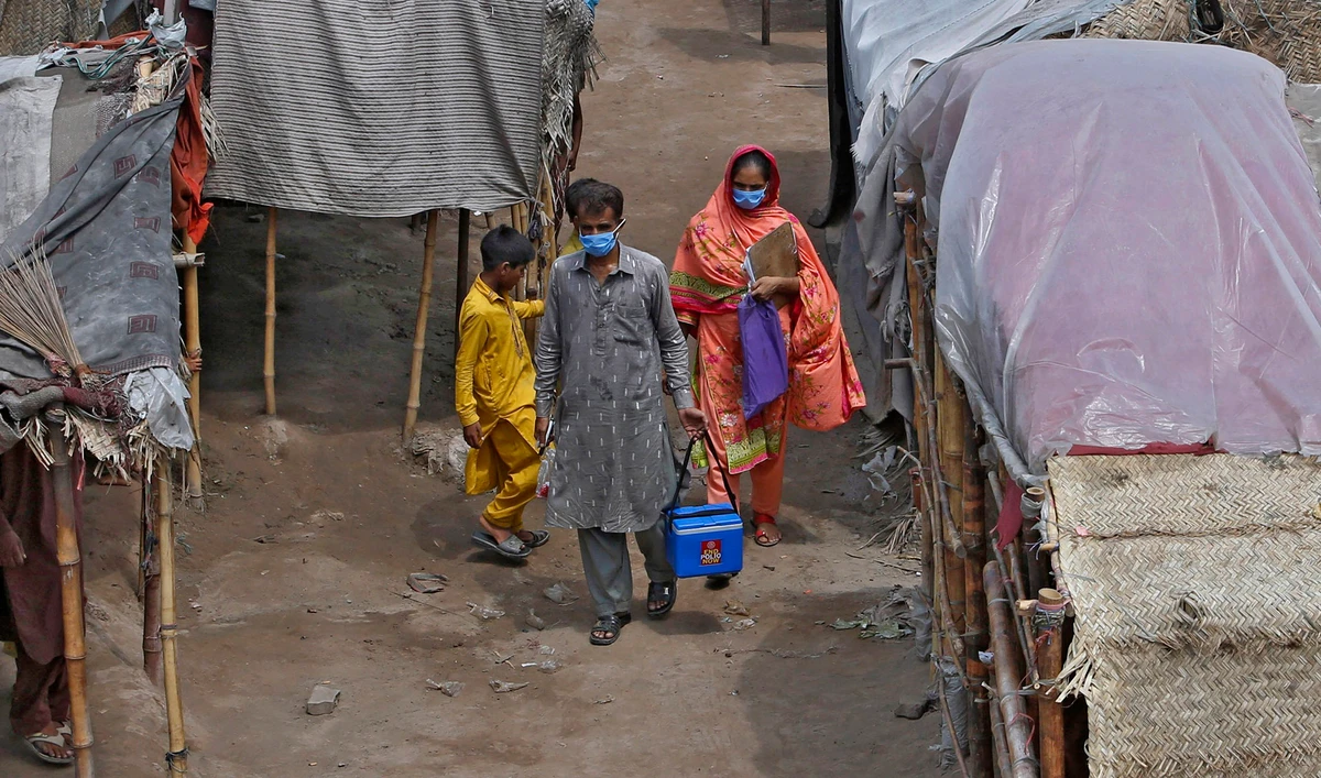 Health workers visit a slum area for polio vaccination in Lahore on Aug. 15, 2020. (AP)