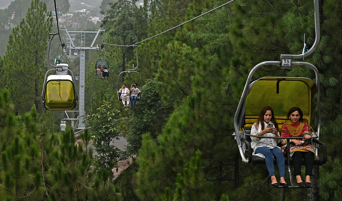 Tourists sit on chairlifts at the Patriata Resort near Murree, some 65 km form Islamabad on Aug. 16, 2020, after the government announced most of the country's remaining restrictions would be lifted following the drop in COVID-19 coronavirus new cases for several weeks. (AFP)