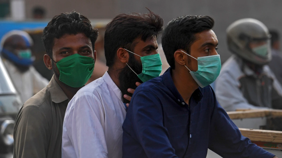 Commuters wearing facemasks, to stay protected from COVID-19 coronavirus, ride on a bike on a street in Karachi on June 22, 2020. (AFP/File)