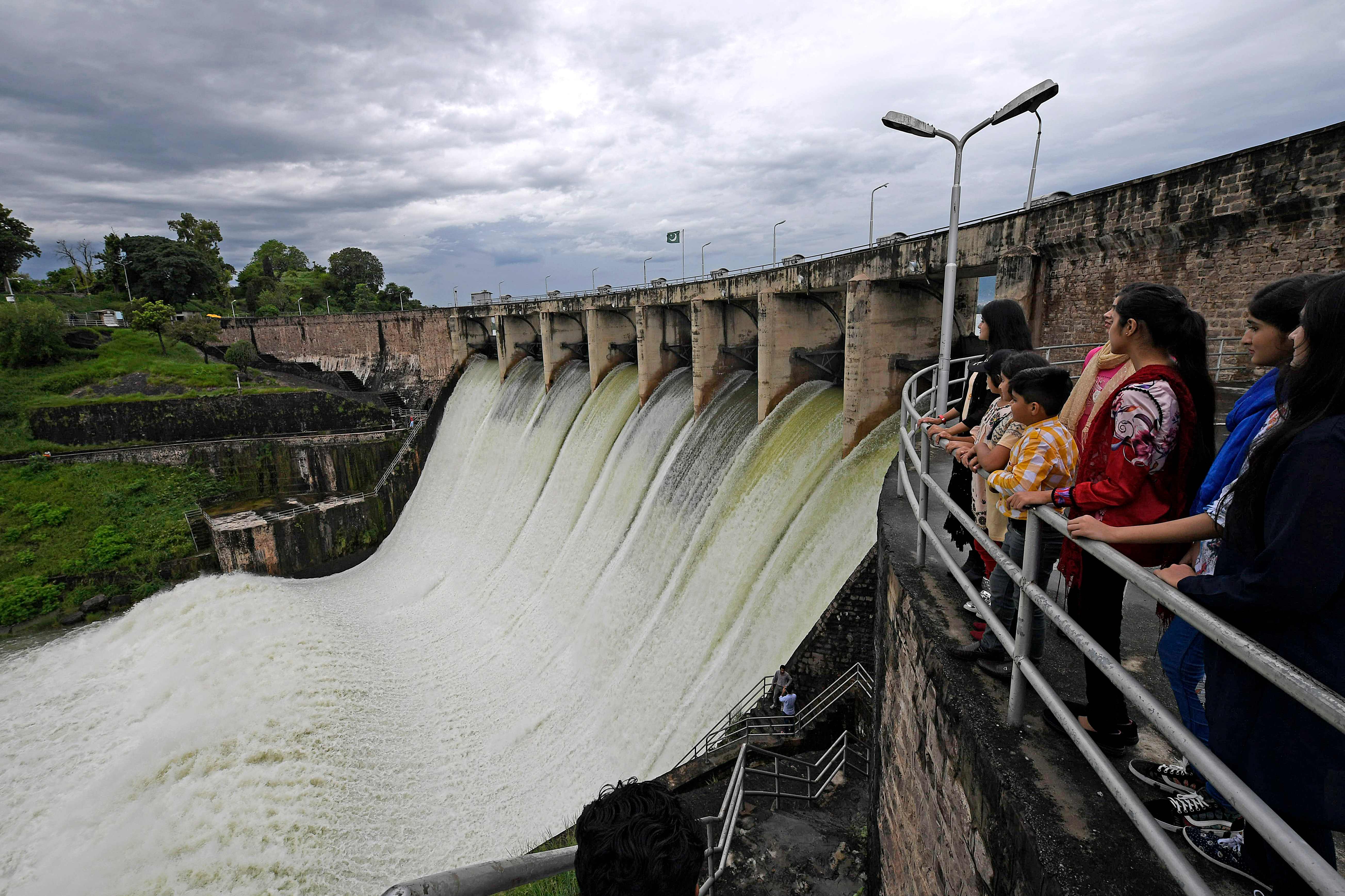People watch the Rawal Dam after the spillway opened due to heavy monsoon rains, in Islamabad on August 31, 2020. (AFP)