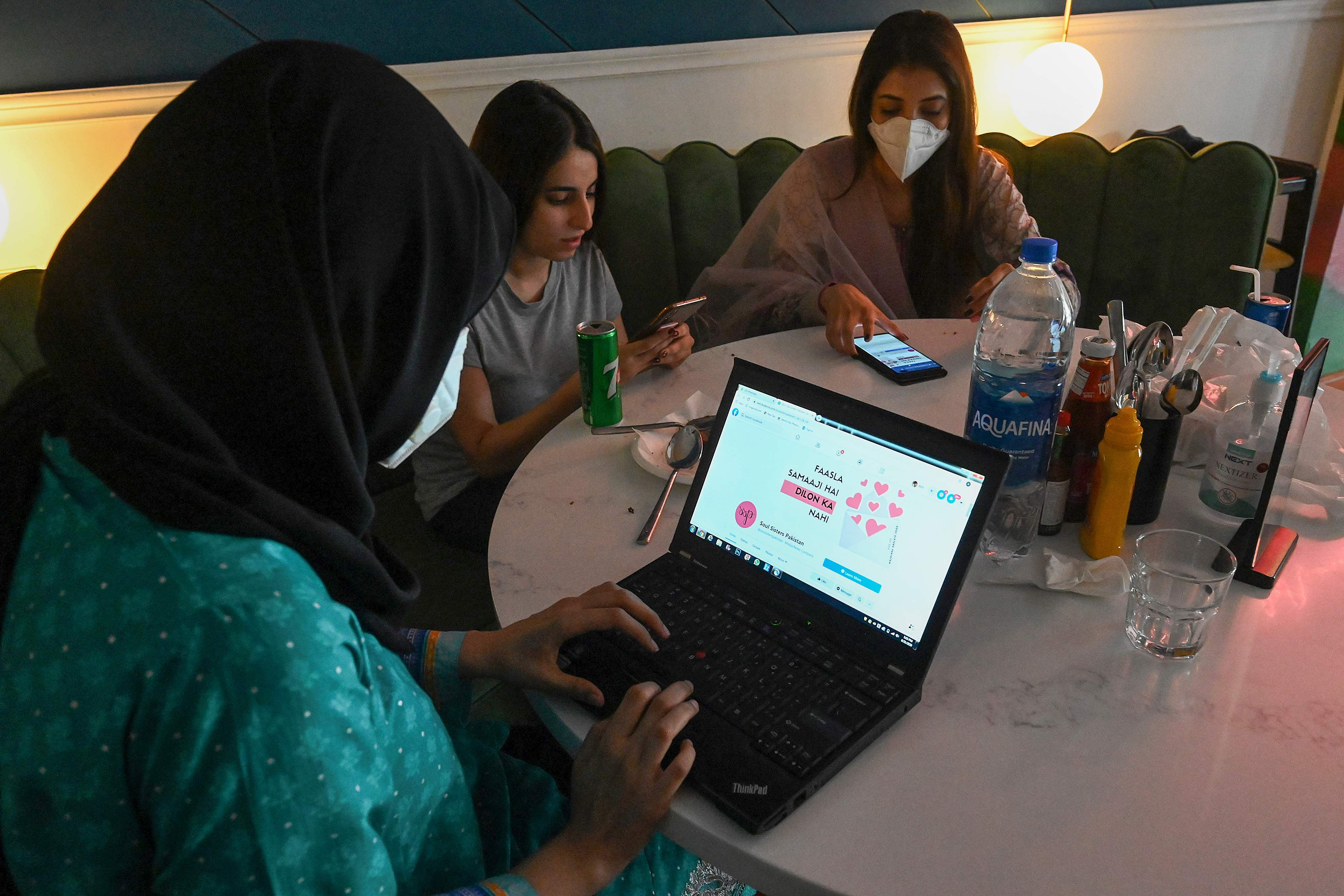 In this picture taken on August 31, 2020, women discuss as they check out the social online group 'The Soul Sisters Pakistan' on their Facebook page, in Lahore. (AFP)