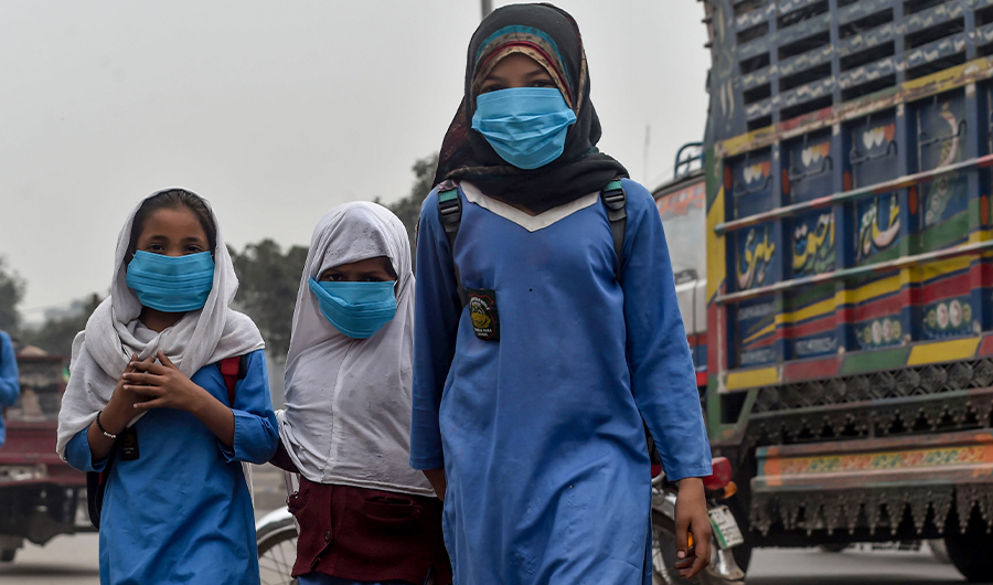 Students wear masks as they go to school amid heavy smog conditions in Lahore on November 14, 2019. (AFP)