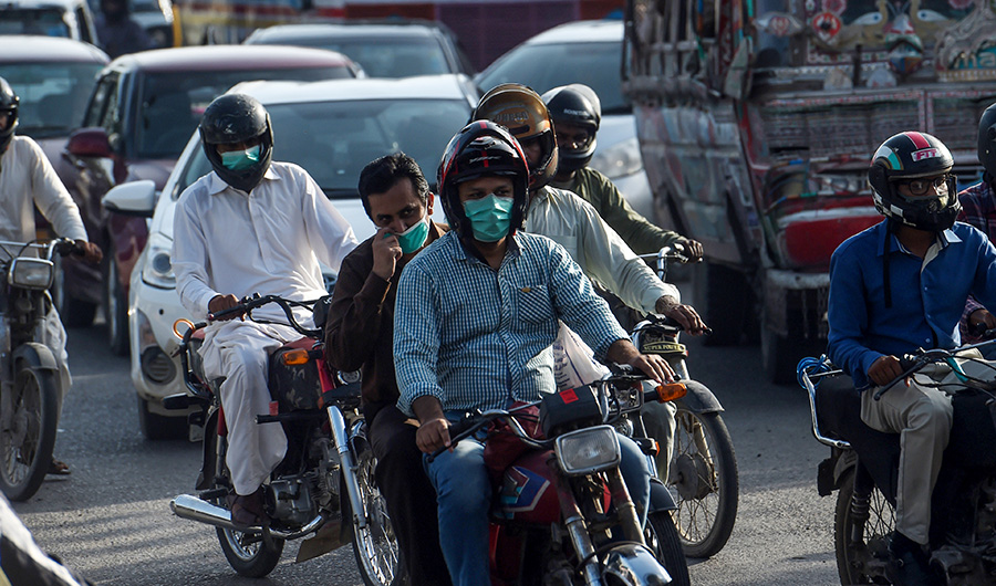Motorists wearing facemasks as a preventive measure against the spread of the COVID-19 coronavirus make their way on a busy street in the Pakistan's port city of Karachi on July 15, 2020. (AFP)