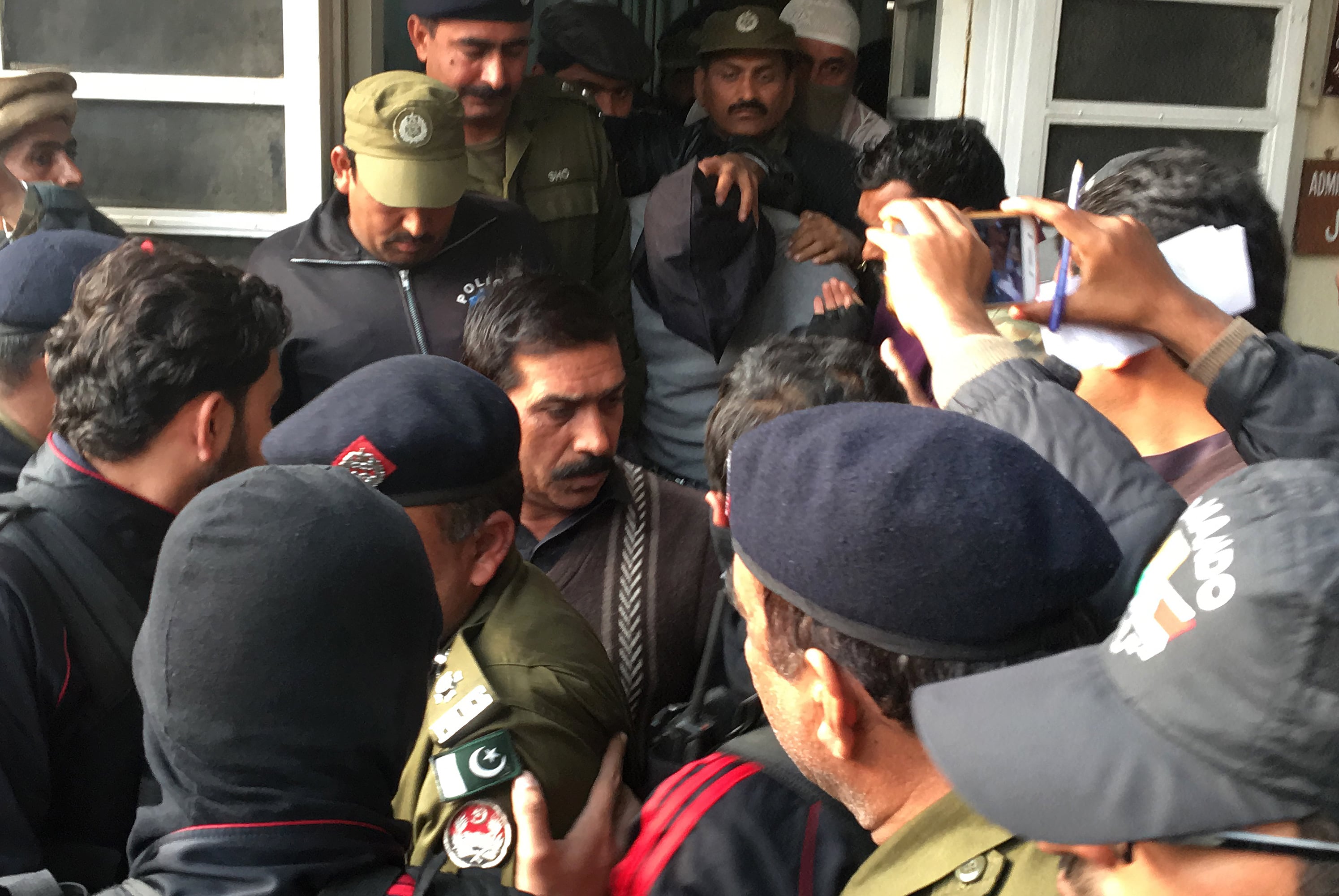 Pakistani policemen escort the suspect accused of raping and murdering a young girl as they leave an anti-terrorist court in Lahore on January 24, 2018. (AFP)