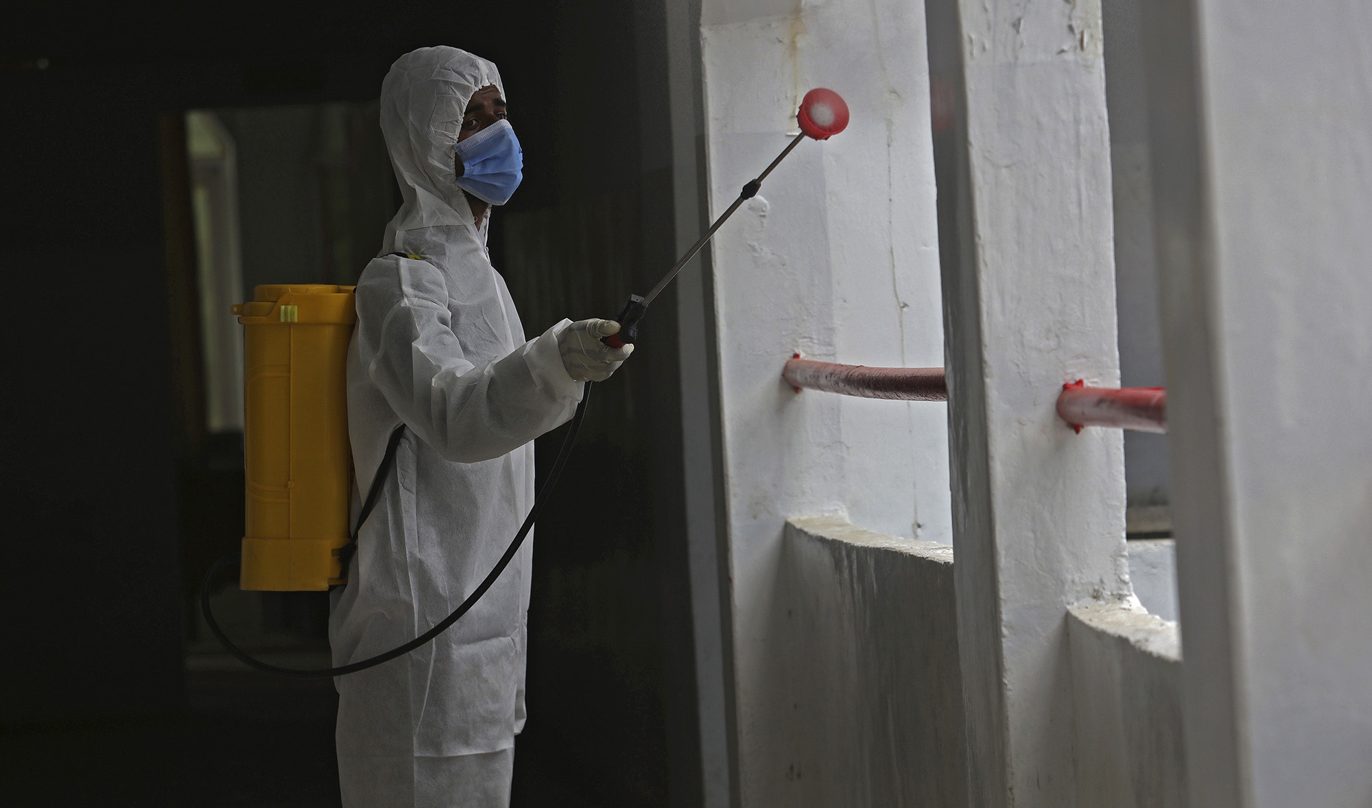 A worker sprays disinfectant in a school as preparations for reopening of educational institutions that were closed in March are finalized, in Karachi, Pakistan, Monday, Sept. 14, 2020. (AP)