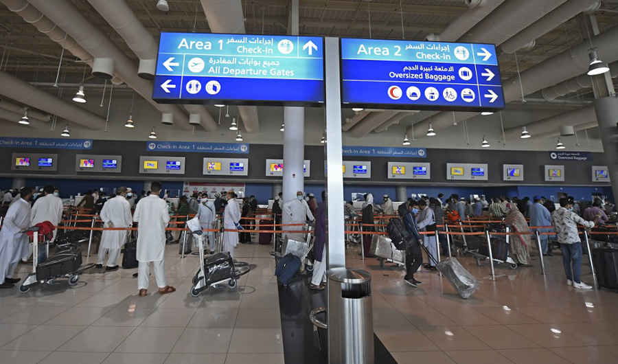 In this file photo, Pakistani nationals check in at the Dubai International Airport before leaving the Gulf Emirate on a flight back to their country, on May 7, 2020, amid the novel coronavirus pandemic crisis. (AFP)