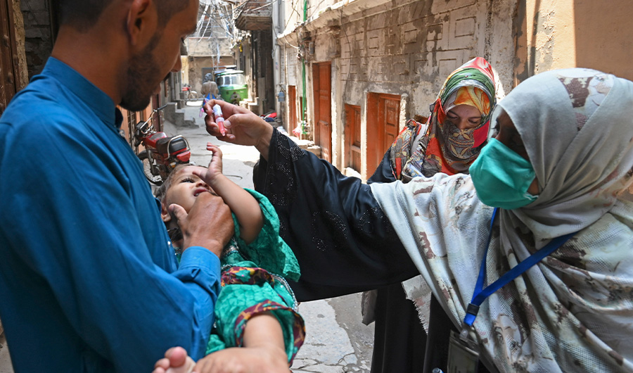 A health worker administers polio vaccine drops to a child during a polio vaccination door-to-door campaign in Lahore on July 20, 2020. (AFP)