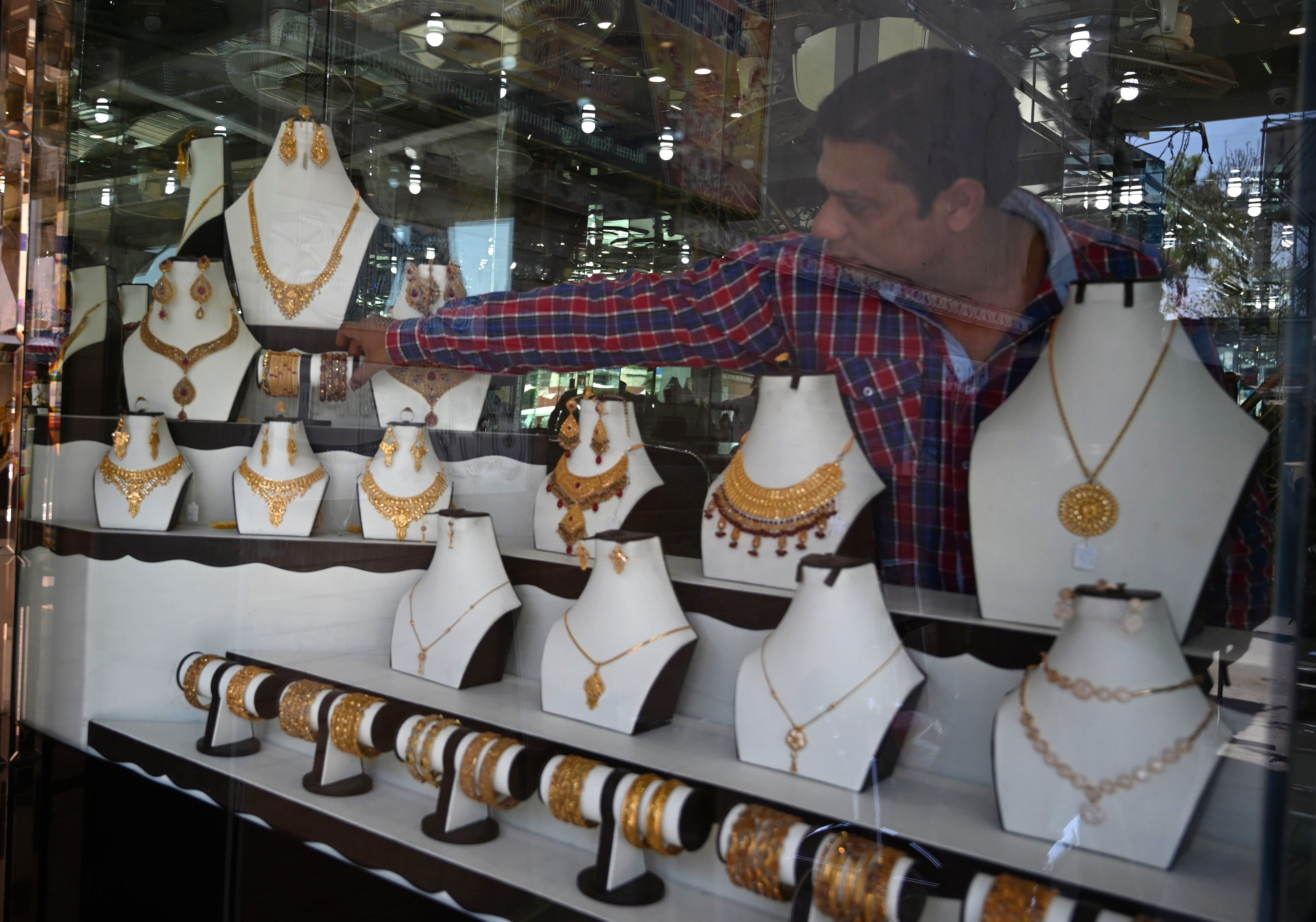 In this pictures taken on April 22, 2019, a Pakistani jeweller arranges jewellery in a window at his shop in Rawalpindi. (AFP)