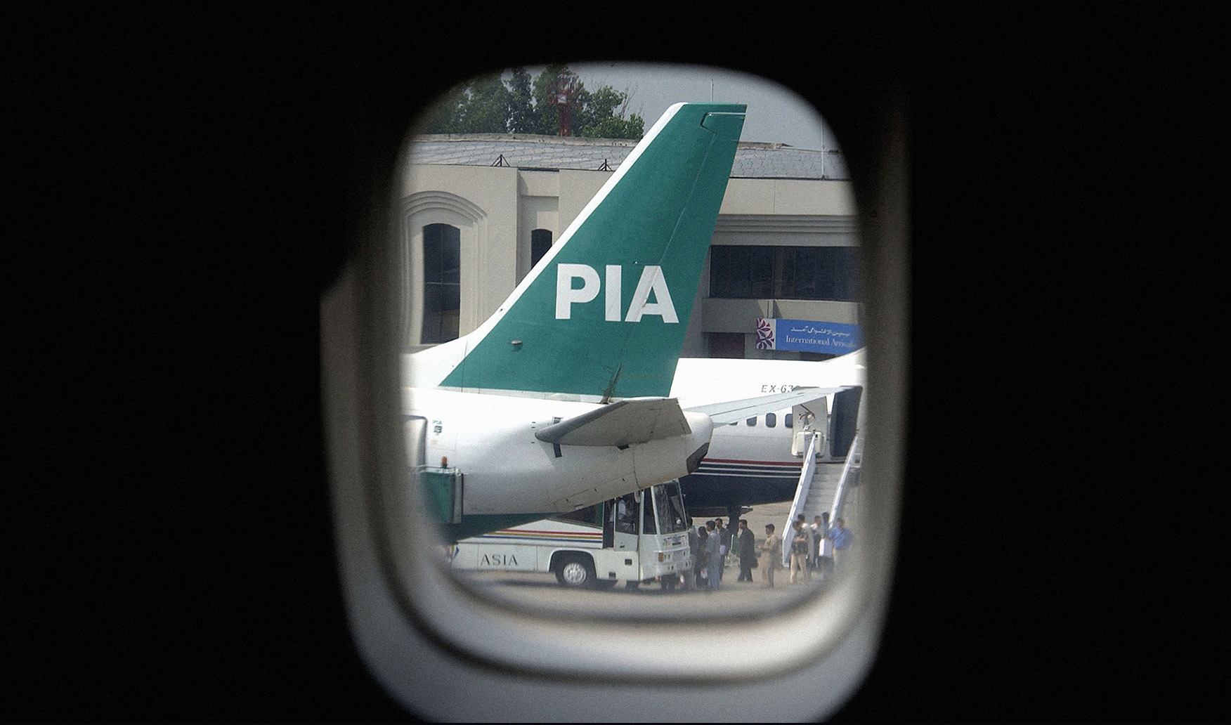 This file photo taken on July 9, 2003, shows a view through an aircraft window of a Boeing 747 tail fin of an aircraft of Pakistan International Airlines (PIA). (AFP)