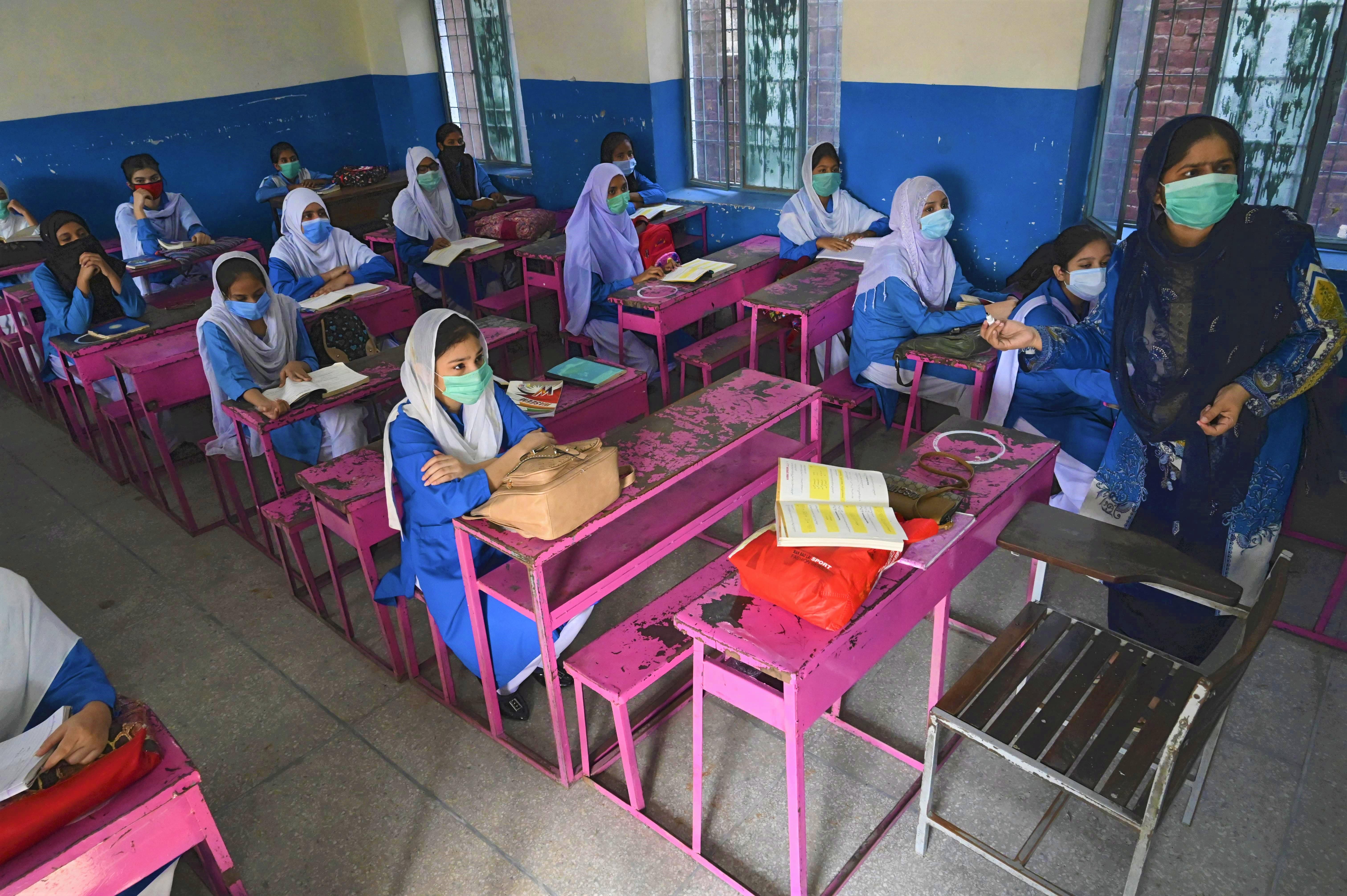 Students wearing facemasks attend a class at a government school in Lahore on September 15, 2020 after the educational institutes were reopened nearly six months after the spread of the Covid-19 coronavirus. (AFP)
