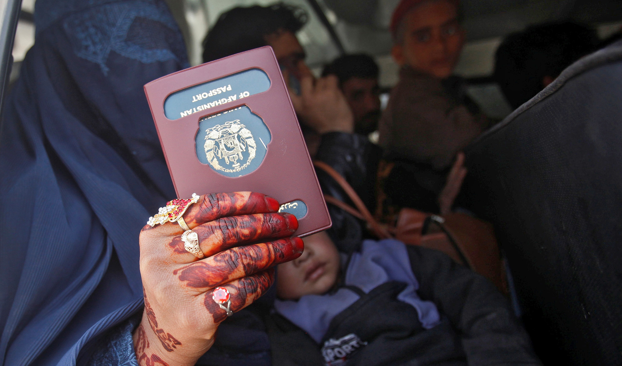 An Afghan woman holds her passport for the camera as she arrived with others to return to their home country at the border post in Torkham, Pakistan, March 7, 2017. (REUTERS/File)