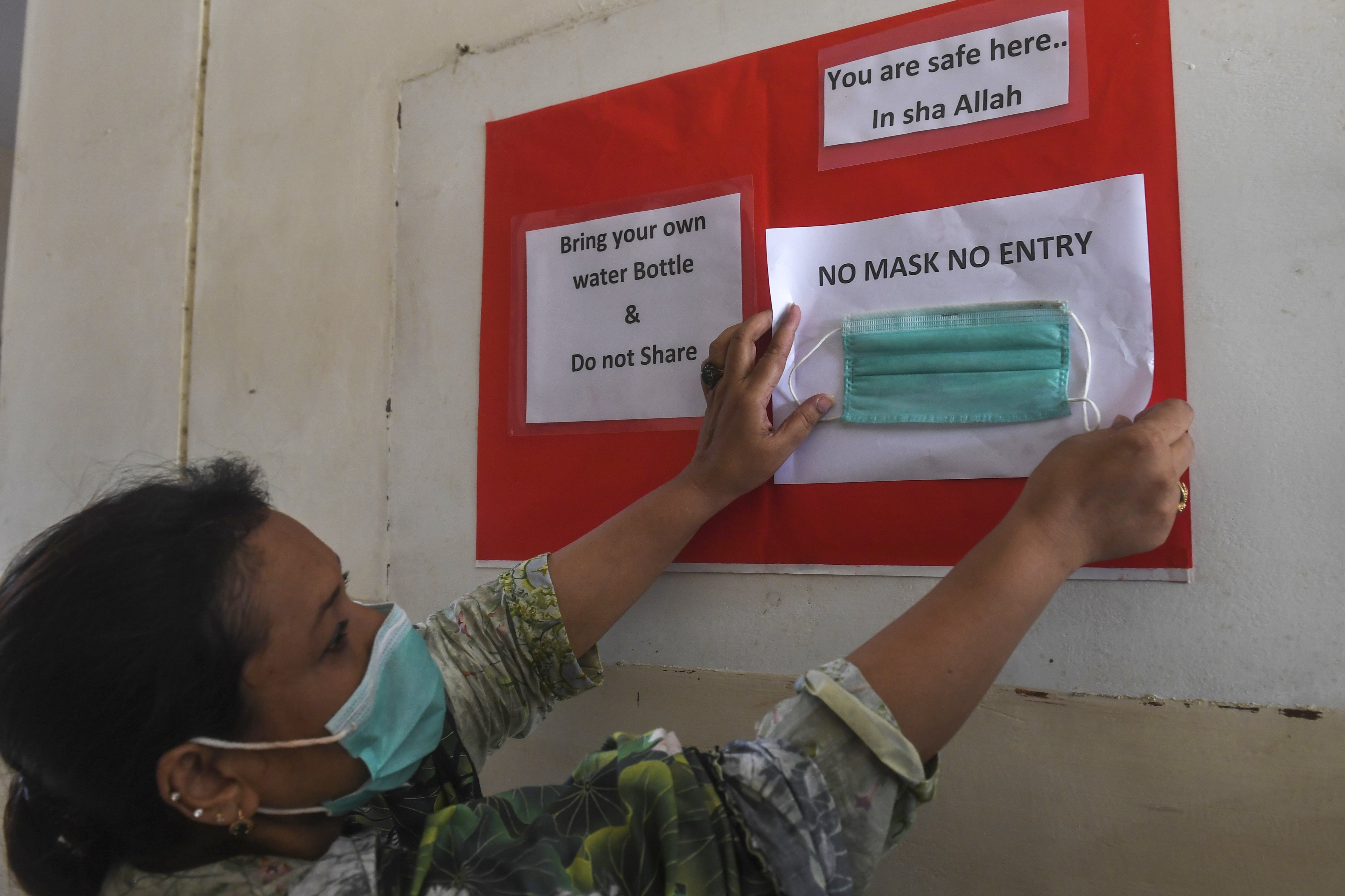 A teacher puts a sign up in a government school following the government's announcement to reopen educational institutes starting from September 15 after nearly six months under lockdown due to the COVID-19 coronavirus, in Karachi on September 14, 2020. (AFP)