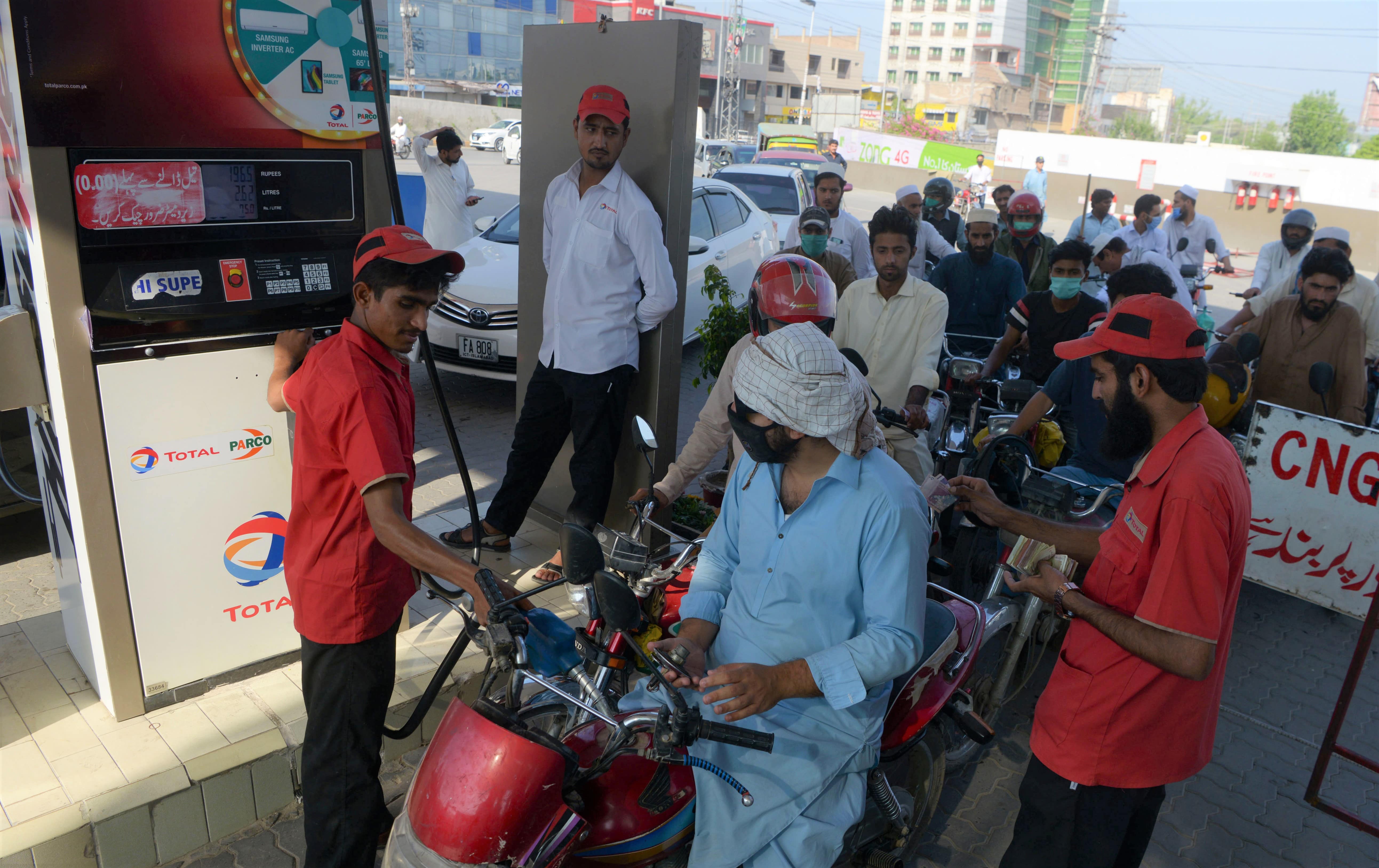 Commuters wait to fill their vehicles tanks at a gasoline station as Pakistan's government reduced prices of petroleum due a decrease of the global oil market, in Peshawar on June 2, 2020. (AFP)