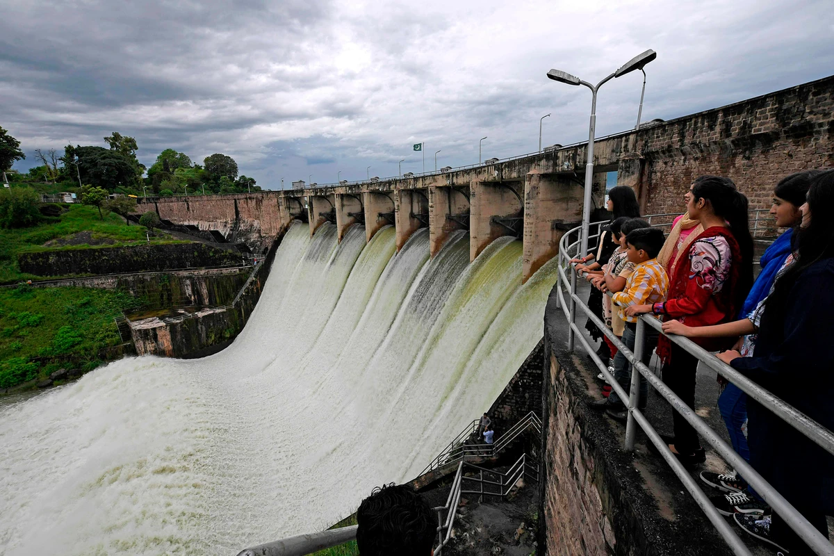 People watch the Rawal Dam after the spillway opened due to heavy monsoon rains, in Islamabad on August 31, 2020. (AFP)
