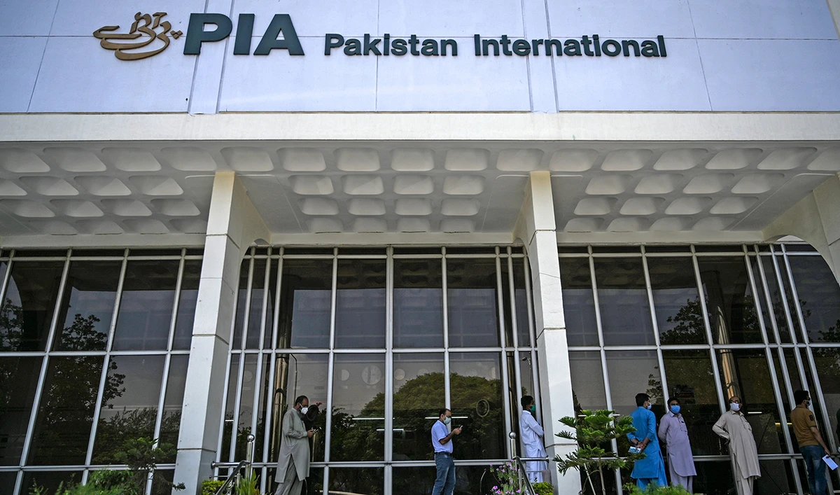 People stand in queue as they wait their turn to buy flight tickets outside Pakistan International Airlines (PIA) office in Islamabad on July 1, 2020. (AFP/File)