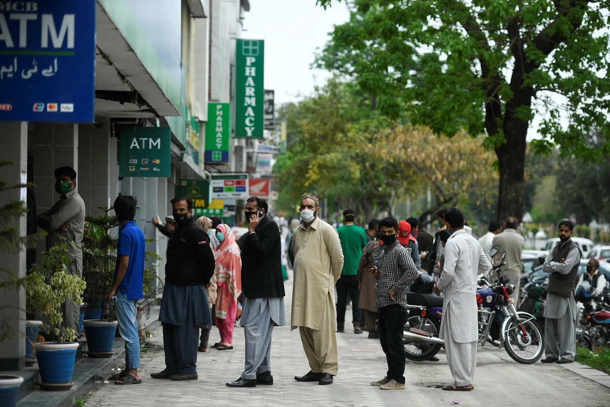 Residents wearing facemasks wait for their turn to withdraw money outside a bank during a government-imposed nationwide lockdown as a preventive measure against the spread of the COVID-19 novel coronavirus in Islamabad on March 30, 2020. (AFP)