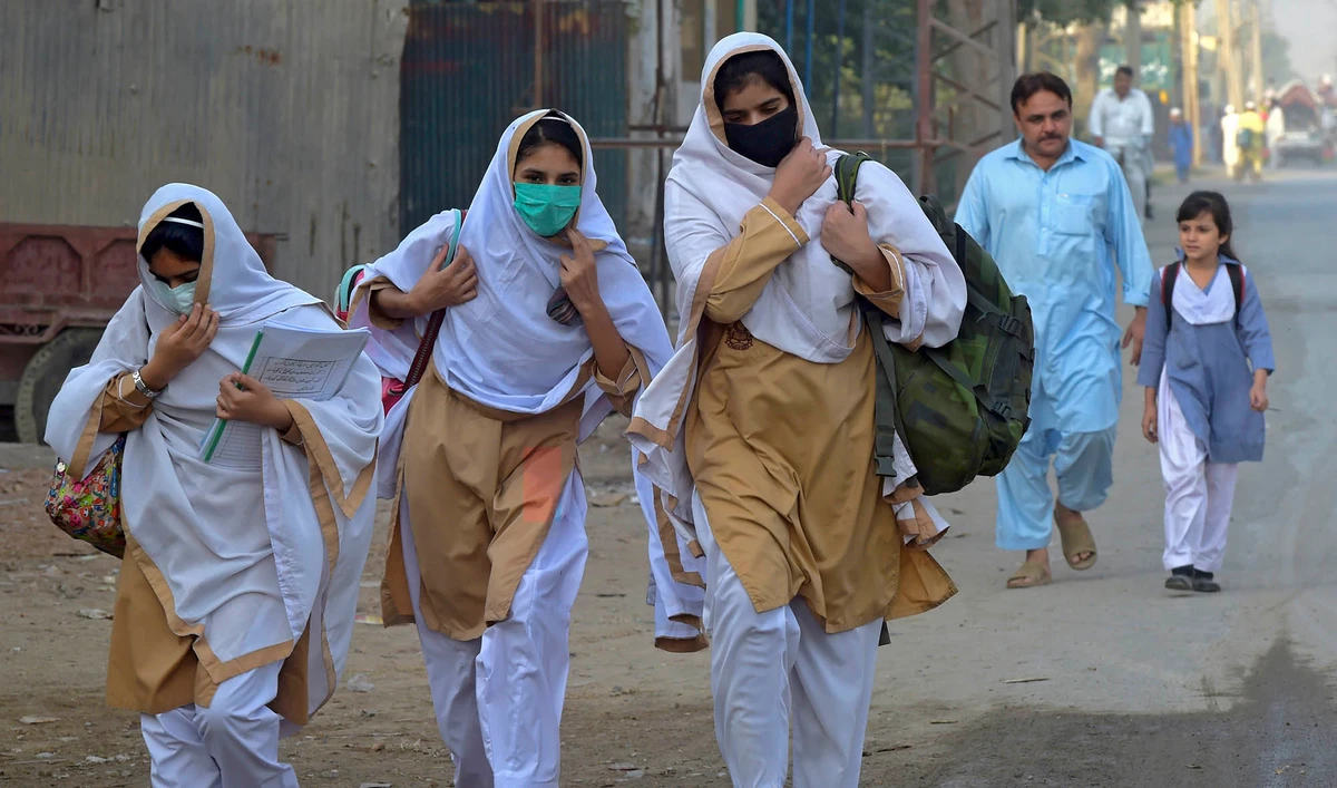 Students wearing facemasks walk through a street to their school in Peshawar on Sept. 15, 2020 after the educational institutes were reopened nearly six months after the spread of the Covid-19 coronavirus. (AFP/File)