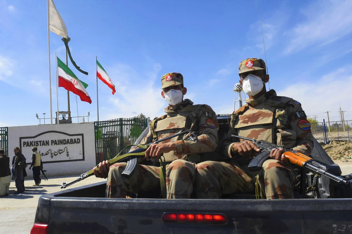 Pakistani soldiers wearing facemasks patrol near the closed Pakistan-Iran border in Taftan on February 25, 2020 as fears over the spread of the COVID-19 coronavirus escalate following an outbreak in neighbouring Iran. (AFP)