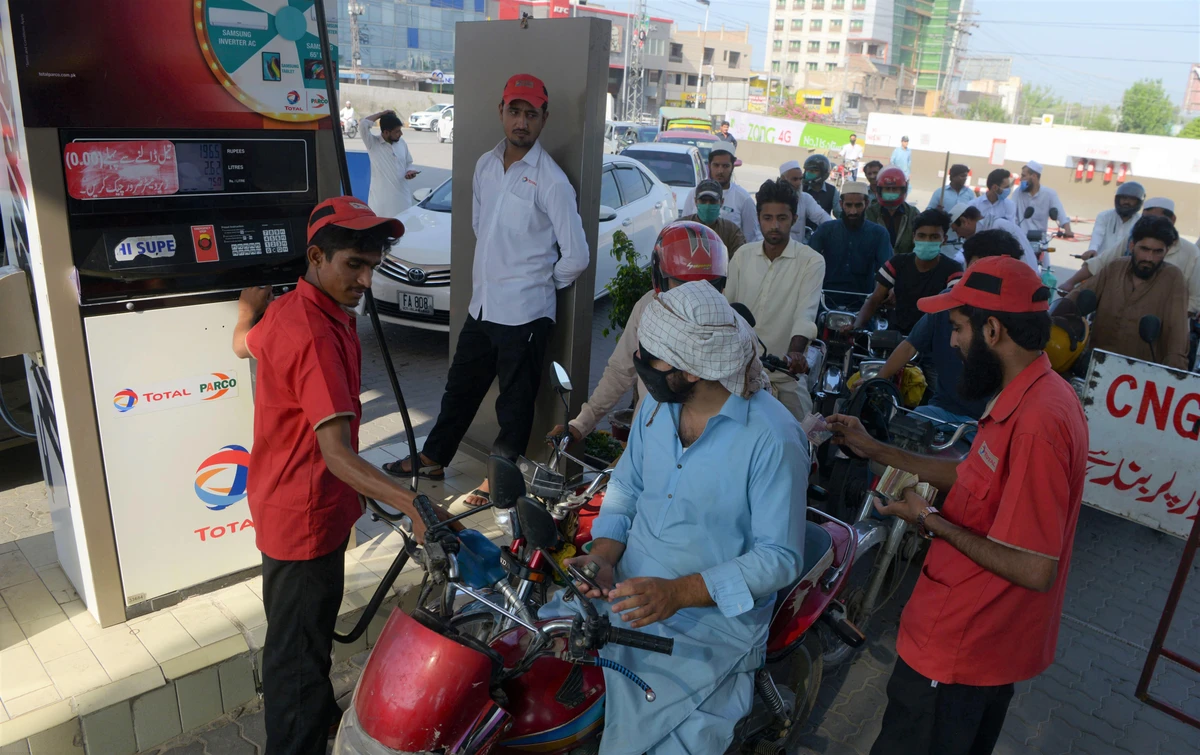 Commuters wait to fill their vehicles tanks at a gasoline station as Pakistan's government reduced prices of petroleum due a decrease of the global oil market, in Peshawar on June 2, 2020. (AFP)