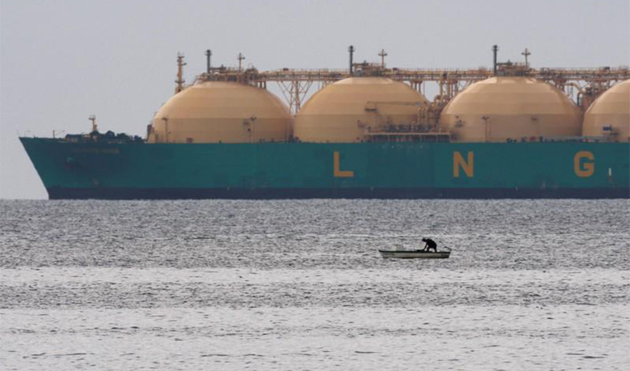 FILE PHOTO: A fisherman stands in his boat as a liquid natural gas tanker (LNG) passes the coast near Havana on June 28, 2009. (REUTERS)
