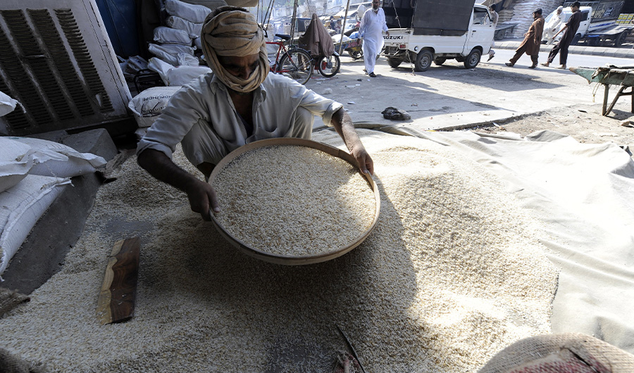 FILE: A Pakistani worker sieves a heap of rice at a wholesale market in Rawalpindi on September 30, 2009. (AFP)