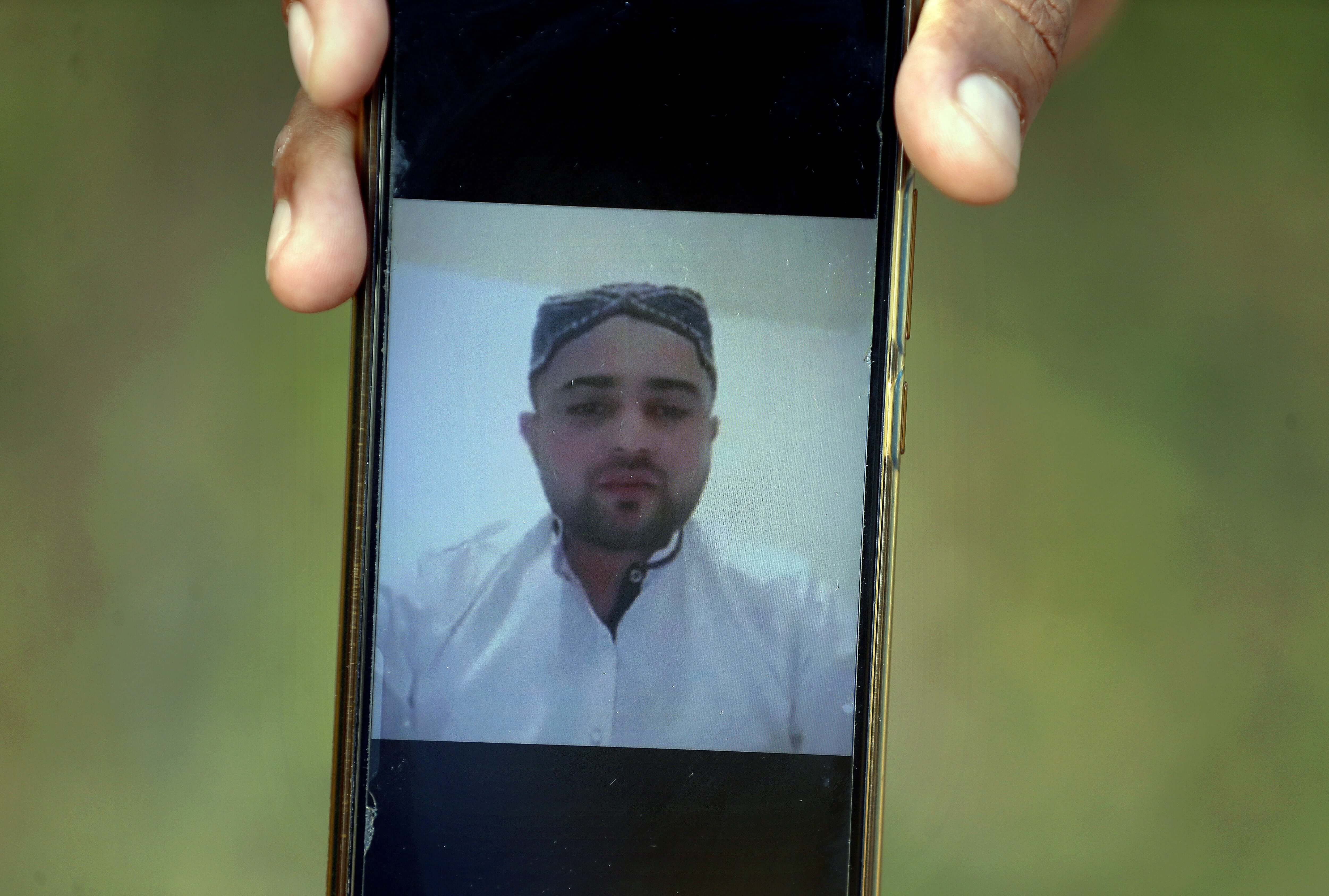 A villager displays a picture of Ali Hassan, a suspect in an attack on two people with a meat cleaver in Paris last month, in his native village of Kotli Qazi, Pakistan, Saturday, Oct. 3, 2020. Hassan is in jail in Paris, but just three years ago he started out like other young men who leave Pakistan for Europe with dreams of a better life. (AP)