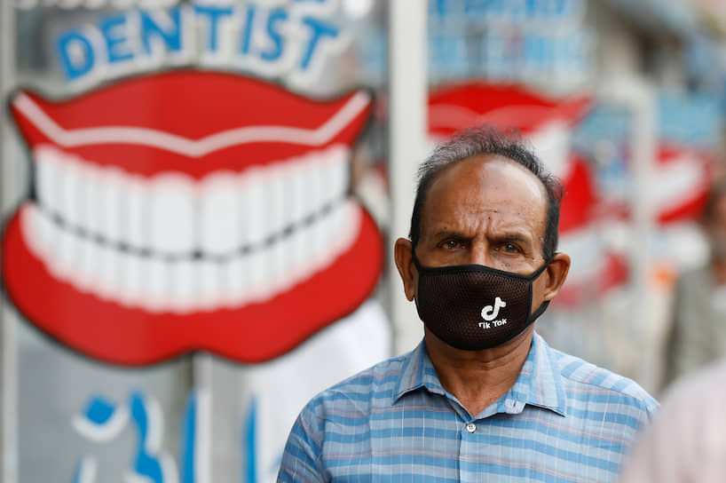 A man wears a protective face mask with the TikTok logo as he walks along dental shops in Karachi, Pakistan July 14, 2020. (REUTERS)