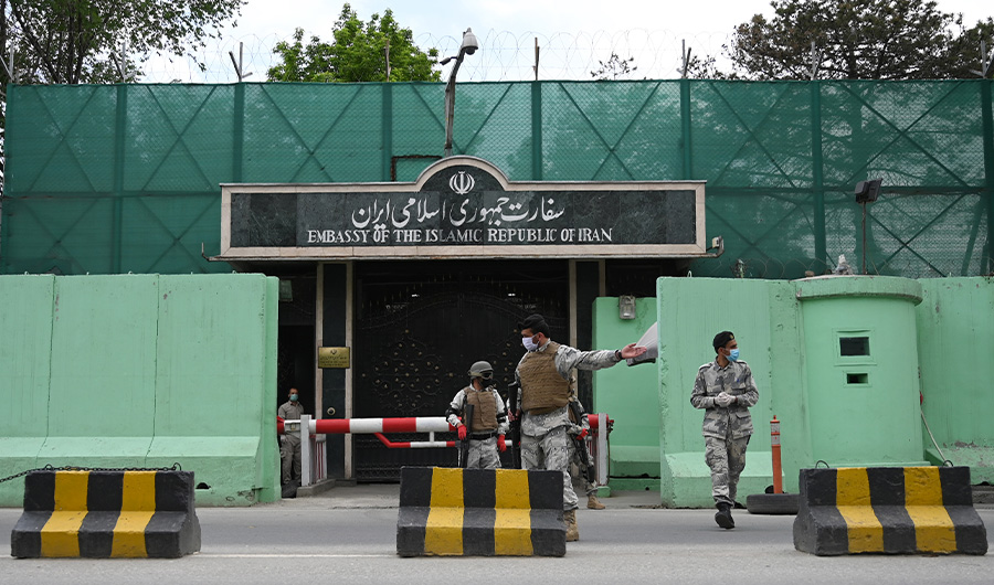 Afghan security personnel stand guard in front of the Iranian embassy as civil society activists hold banners and shout slogans against the Iranian government during a protest, in Kabul on May 11, 2020. (AFP / File photo)
