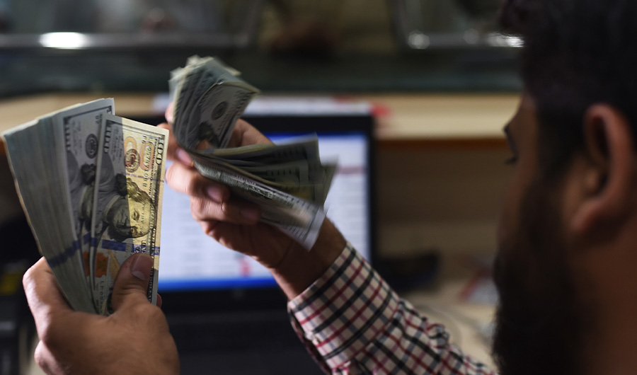 A Pakistani dealer counts US dollars at a currency exchange shop in Karachi on October 9, 2018. (AFP)