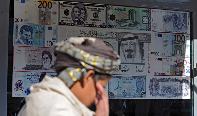A pedestrian walks past a foreign currency exchange shop in Quetta on Dec. 8, 2011. (AFP/File)