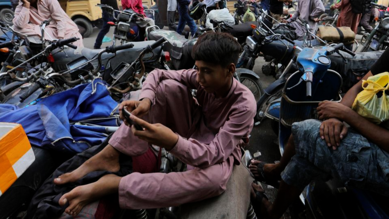 A youngster uses the social media app TikTok on his phone, at a market in Karachi, Pakistan, Tuesday, July 21, 2020. (AP)