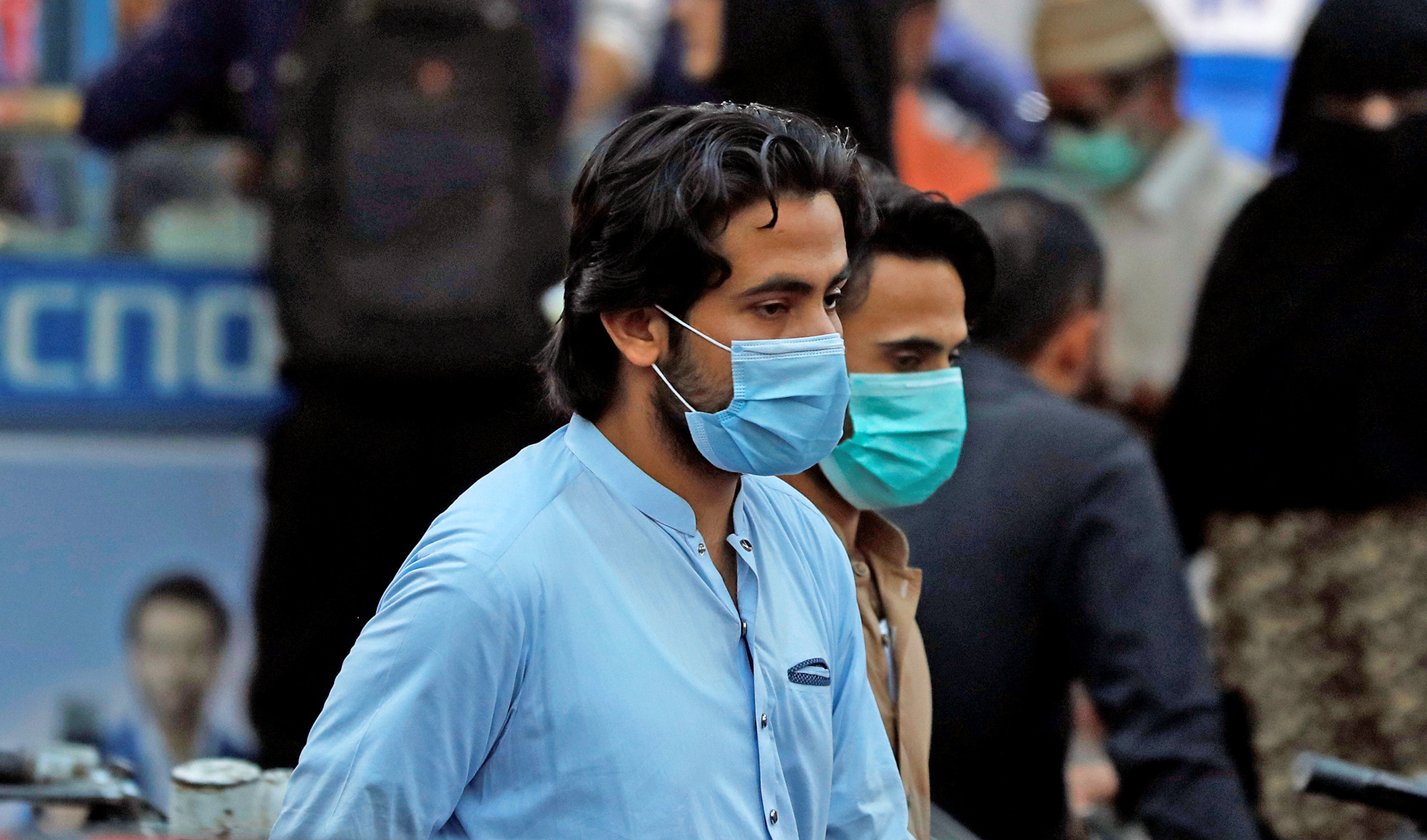 Men wearing protective masks walk along a market amid the coronavirus disease (COVID-19) outbreak, in Karachi on Oct. 14, 2020. (REUTERS)