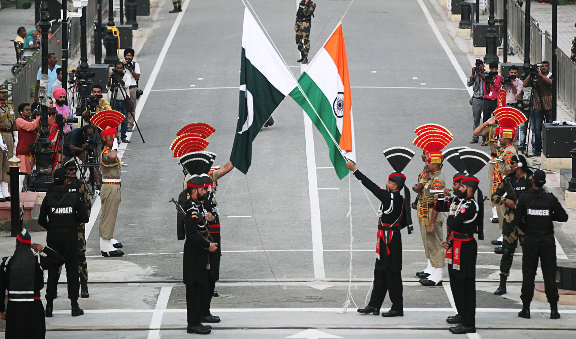 Pakistani Rangers (wearing black uniforms) and Indian Border Security Force (BSF) officers lower their national flags during parade on the Pakistan's 72nd Independence Day, at the Pakistan-India joint check-post at Wagah border, near Lahore on Aug. 14, 2019. (REUTERS/File)