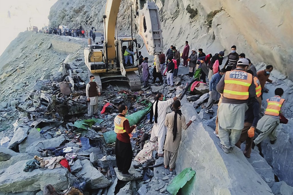 Rescuers search for the bodies of the victims following a landslide on the Jaglot-Skardu road in the Tangos area on Oct. 18, 2020. At least 16 people were killed when a passenger coaster was forced off road by a landslide in a mountainous area of northern Pakistan. (AFP)
