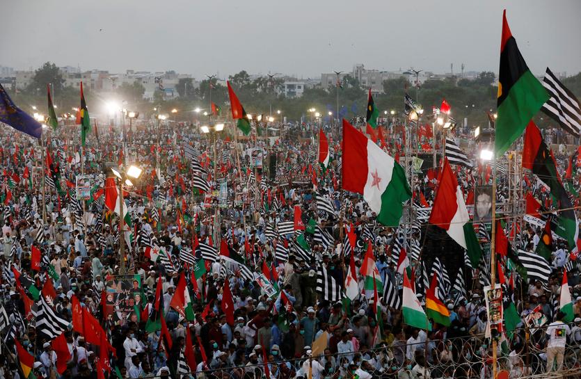 Supporters of Pakistan Democratic Movement (PDM), an alliance of political opposition parties, wave flags as they listen to their leaders during an anti-government protest rally in Karachi, Pakistan October 18, 2020. (REUTERS)