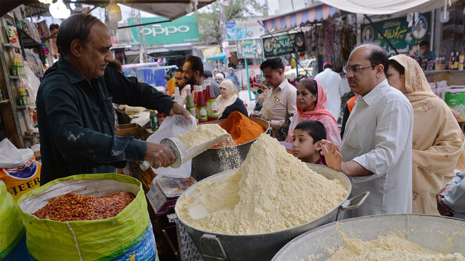 In this file photo, Pakistani customers buy flour and other items ahead of the start of Ramadan in Rawalpindi on May 15, 2018. (AFP)