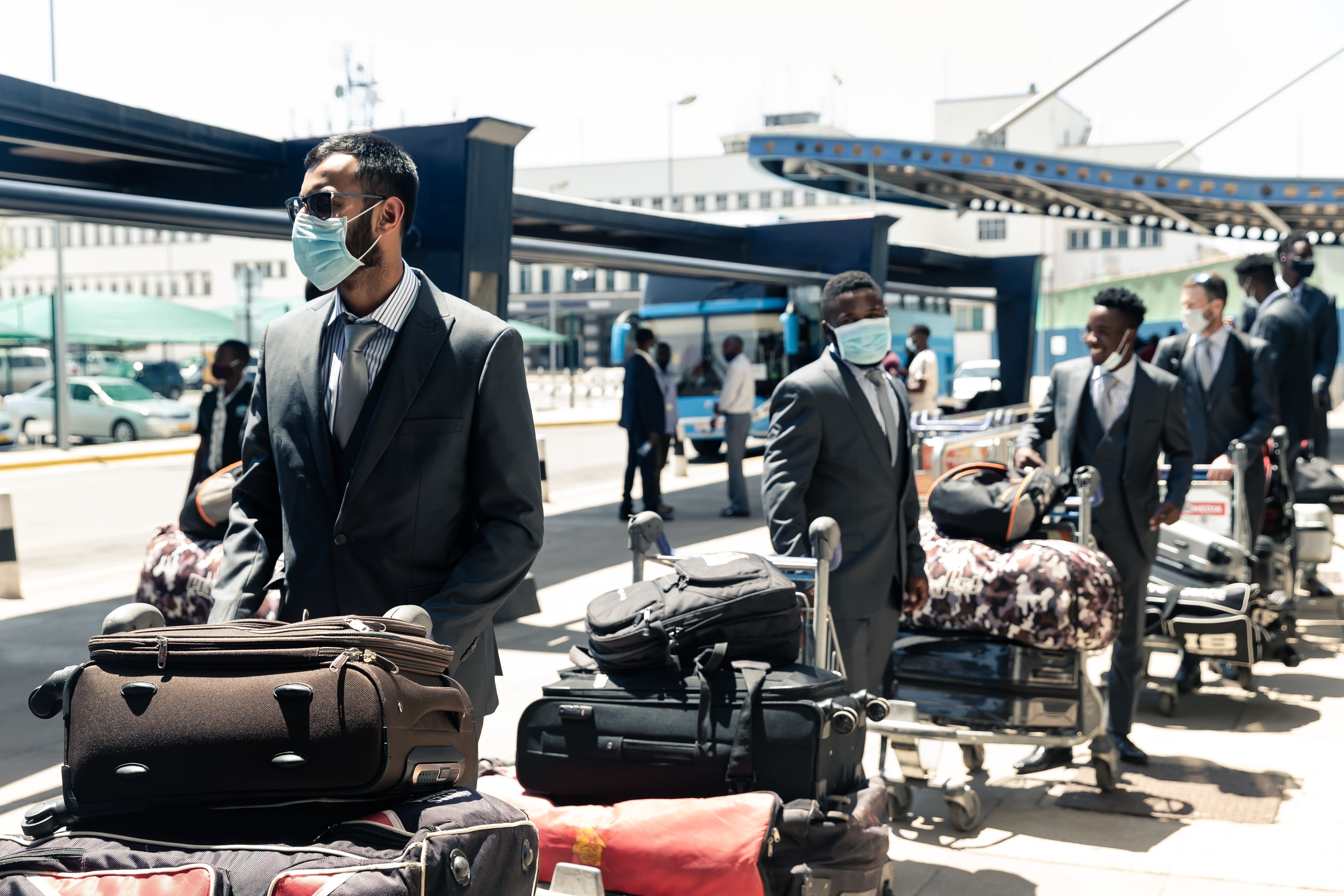 Faraz Akram (L) waits first in line for sanitisation ahead of his team mates as the Zimbabwe cricket squad of 20 players departs the country at Robert Mugabe International Airport in Harare on October 19, 2020 , after having spent seven days in a bio-secure bubble as a preventive measure against the spread of the COVID-19 coronavirus ahead of their tour of Pakistan. (AFP)