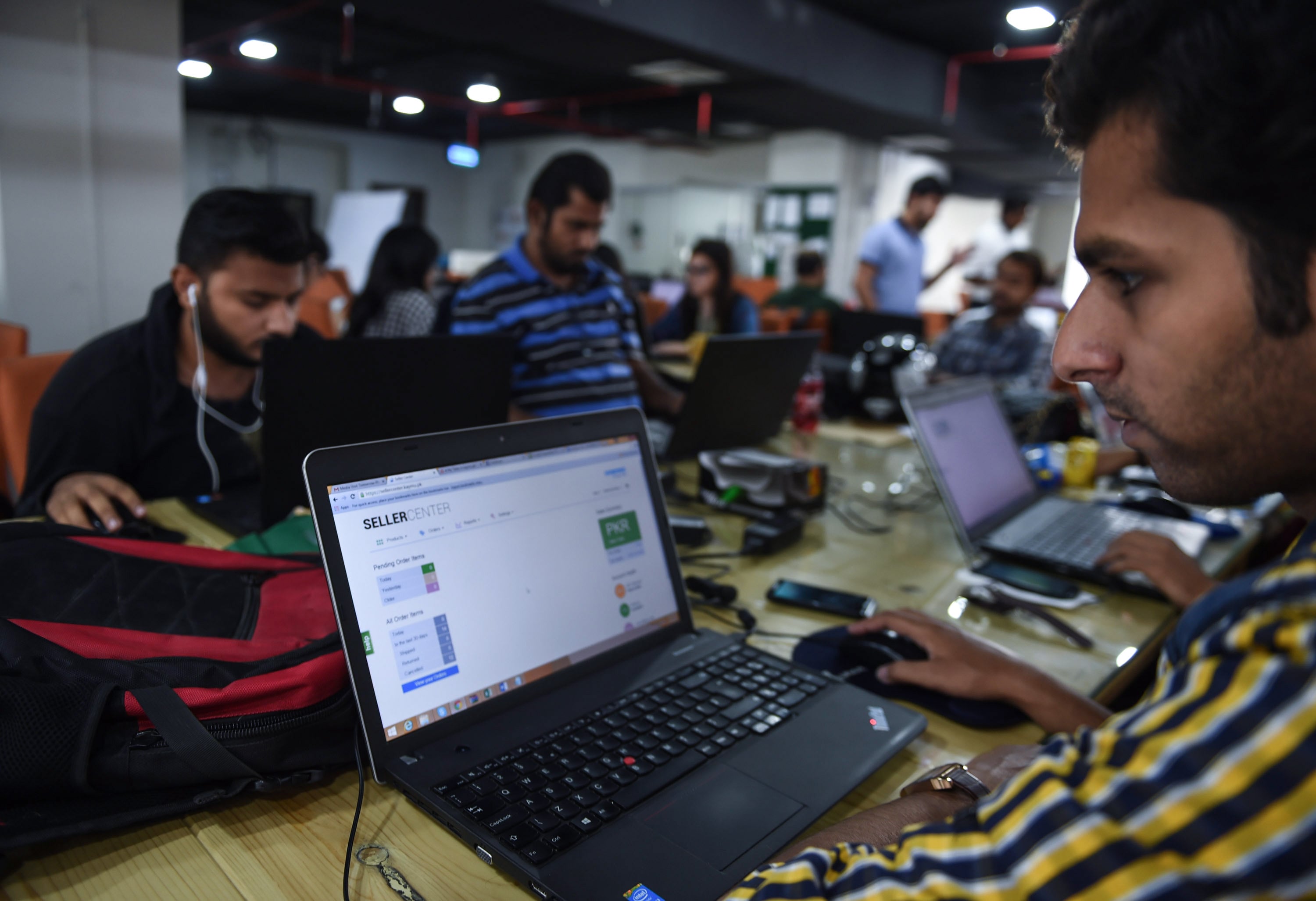 This photograph taken on November 19, 2015 shows Pakistani employees of online marketplace company Kaymu at work in Karachi. (AFP)